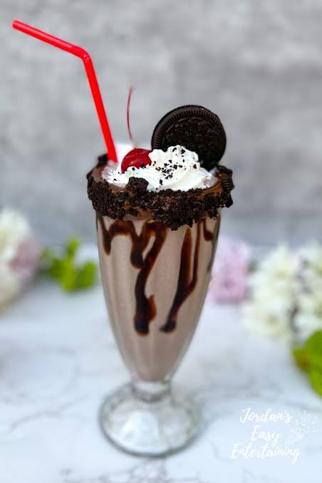Chocolate milkshake with whipped cream, cherry and cookie